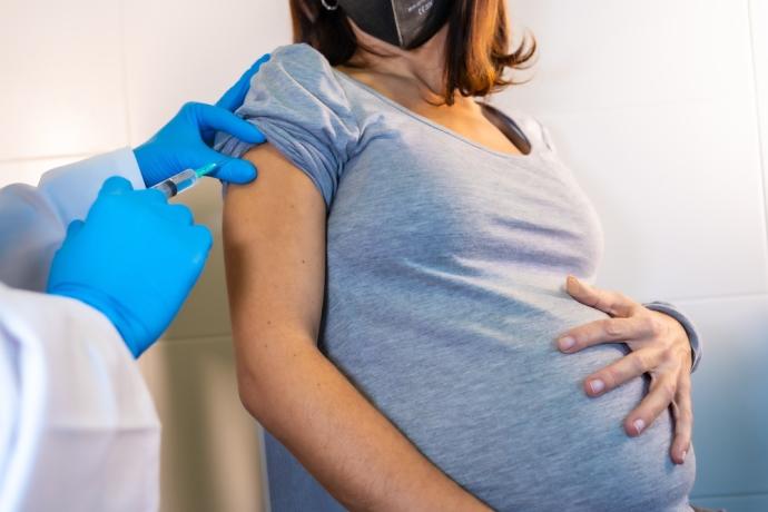 Imagen de una mujer embarazada vacunándose.