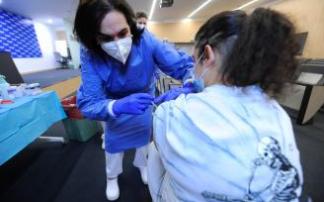 Una sanitaria vacuna a una adolescente del covid. Una sanitaria vacuna a una adolescente del covid.