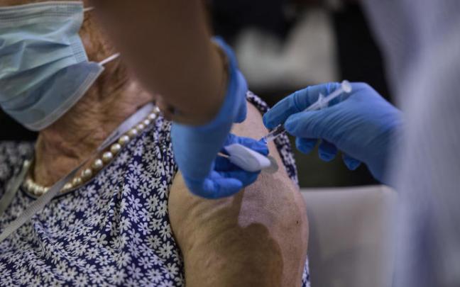 Una sanitaria pone una vacuna a una mujer Una sanitaria pone una vacuna a una mujer