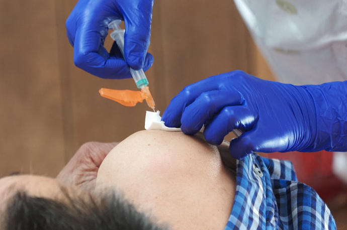 Un hombre recibe una dosis de la vacuna de AstraZeneca.
