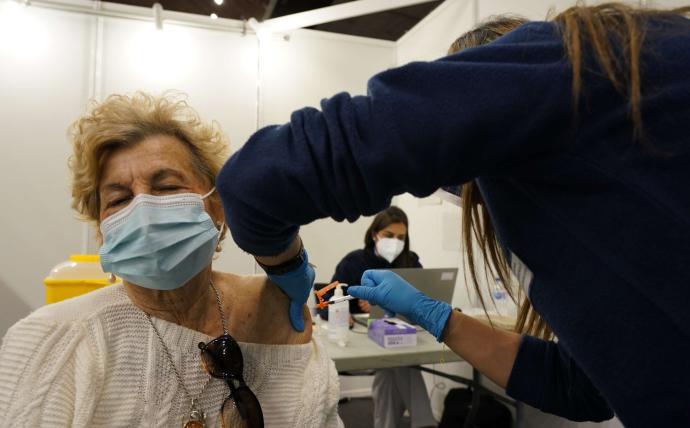 Una mujer recibe la vacuna de unos de los puntos habilitados por Osakidetza
