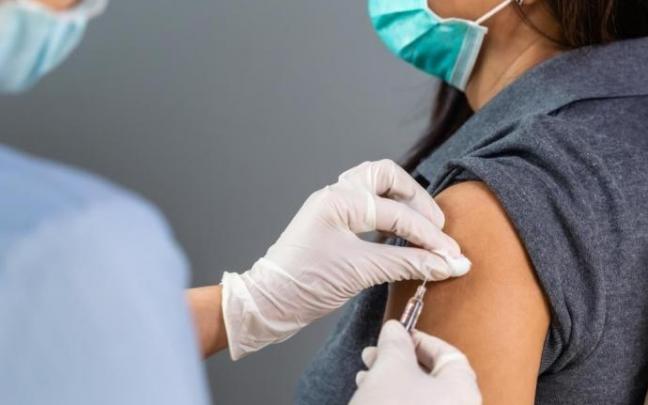 Una sanitaria vacuna a una mujer.