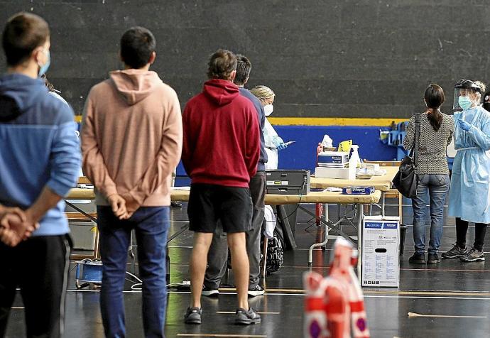 Jóvenes esperan su turno para ser vacunados para poder combatir el covid.