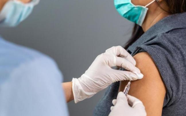 Una sanitaria vacuna a una mujer contra la covid.