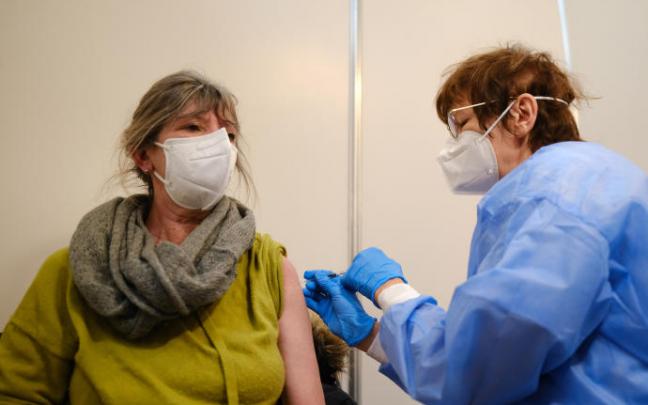 Una sanitaria vacuna a una mujer.