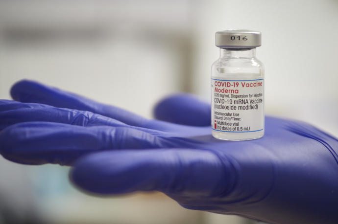 Una profesional sanitaria sostiene un vial de la vacuna de Moderna contra la covid-19.