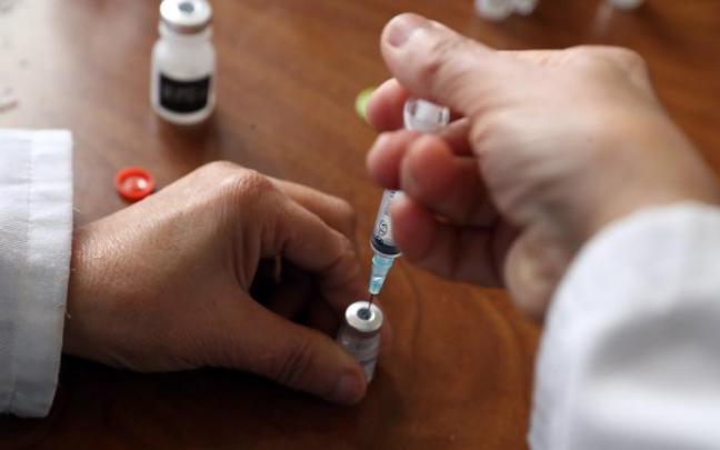 Un sanitario prepara la administración de una vacuna.