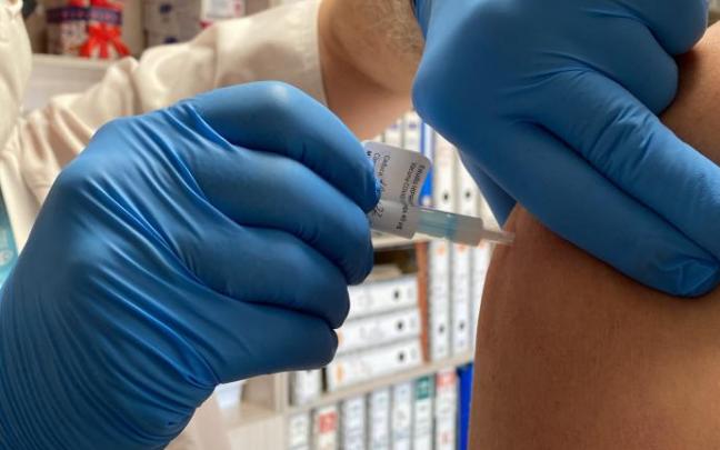 Una sanitaria administra una vacuna a un paciente.