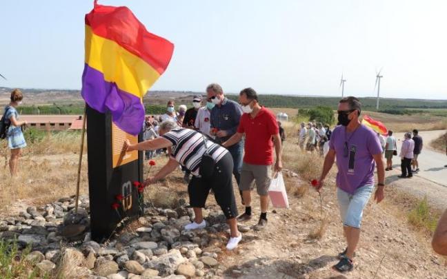Una mujer coloca claveles rojos en el monolito de Valcaldera Una mujer coloca claveles rojos en el monolito de Valcaldera