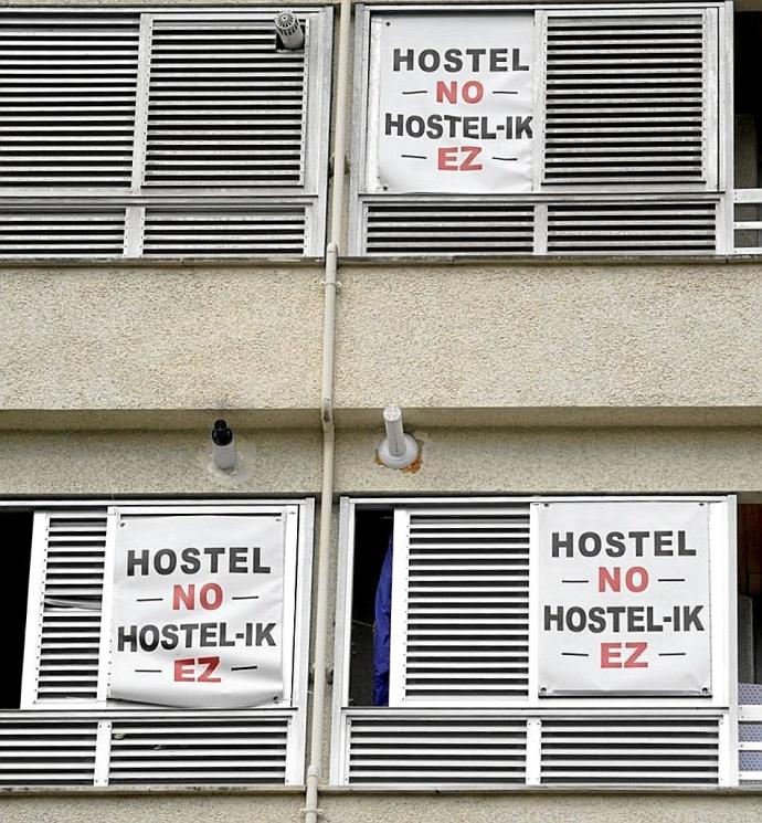 Carteles contra el hostel en las ventanas del vecindario.