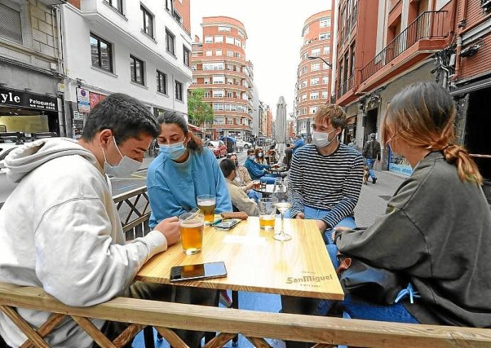 Unos jóvenes, en una terraza de Licenciado Poza. Foto: José Mari Martínez