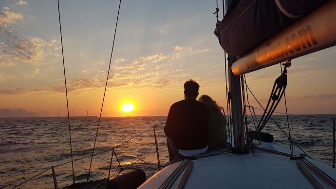 Una pareja observa el atardecer desde la cubierta de un velero, una de las propuestas de Getxo para el verano.