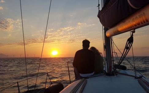 Una pareja observa el atardecer desde la cubierta de un velero, una de las propuestas de Getxo para el verano.
