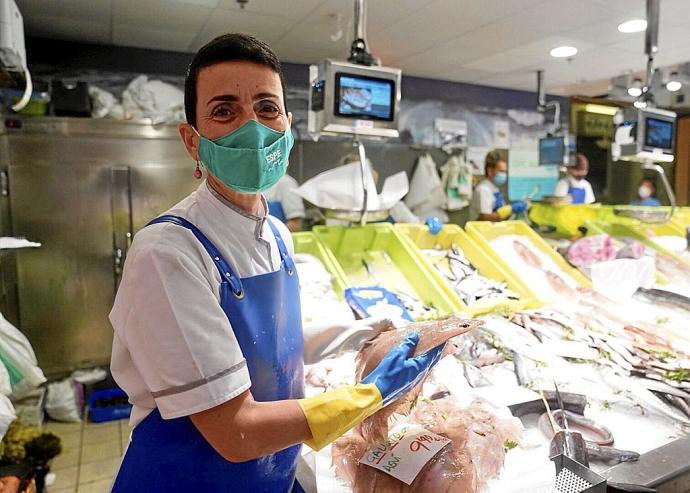 La dueña de la pescadería Espe del mercado de la Bretxa, Carol Archeli, posando con un gallo.