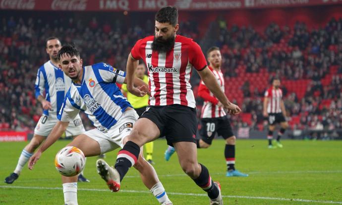 Asier Villalibre golpea el balón con la pierna derecha ante la oposición de Manu Morlanes.