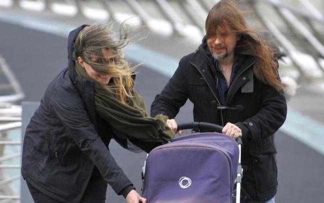 Dos personas caminan por la calle en un día con viento. Dos personas caminan por la calle en un día con viento.