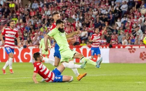 Asier Villalibre trata de rematar en el área del Granada ante la oposición de Escudero.