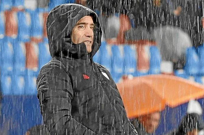 Marcelino sigue el partido bajo la incesante lluvia. Foto: Efe