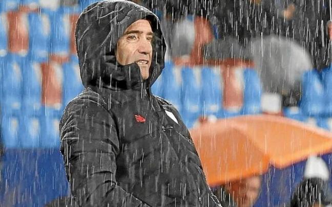 Marcelino sigue el partido bajo la incesante lluvia. Foto: Efe