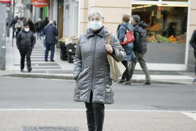 Una mujer protegida con su mascarilla pasea por Vitoria.