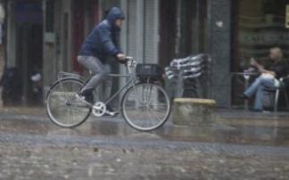 Un joven en bicicleta por Vitoria bajo la lluvia