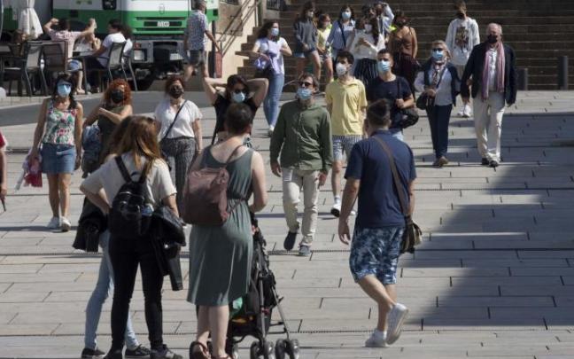 Personas andando por la calle con mascarilla