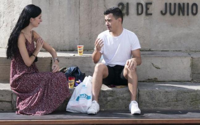 Dos jóvenes charlan sentados en el monumento a la Batalla de Vitoria.