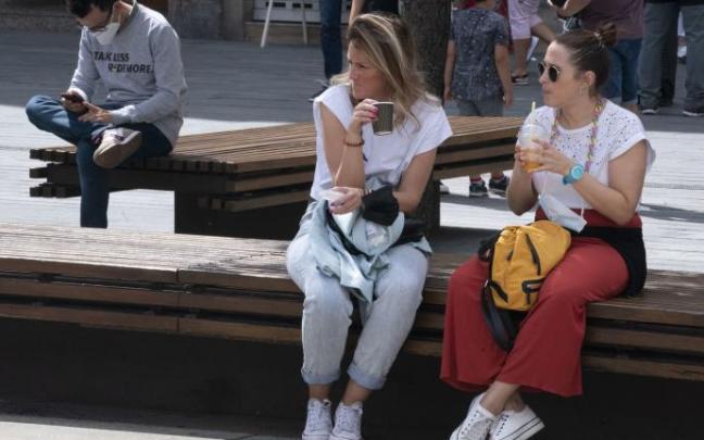 Dos jóvenes descansan en un banco del centro de Vitoria.