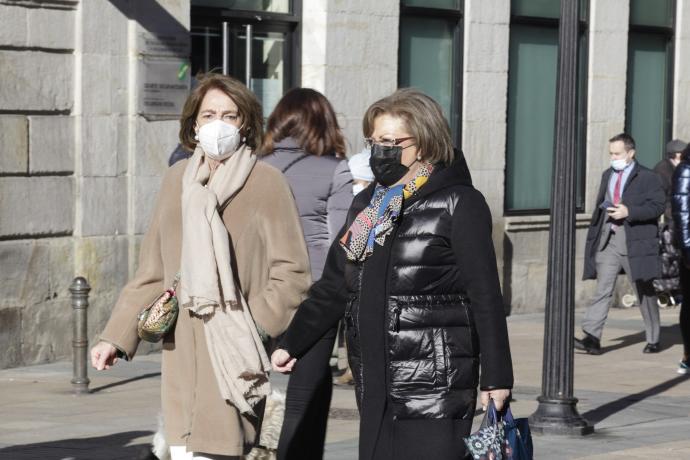 Dos mujeres protegidas con sus mascarillas pasean por Vitoria.