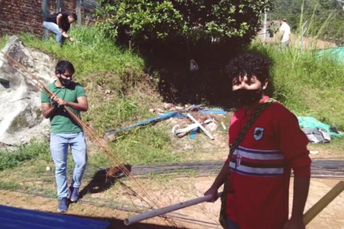 Dos jóvenes colaboran como voluntarios.