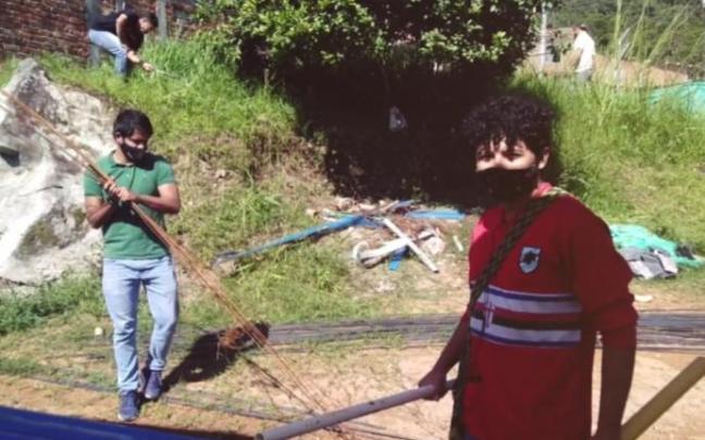 Dos jóvenes colaboran como voluntarios.