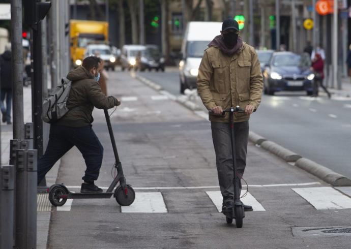 Dos personas, ajenas a la información, circulan en patinete eléctrico por Vitoria