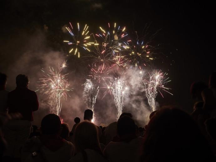 Una multitud observa un espectáculo de fuegos artificiales.