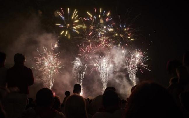 Una multitud observa un espectáculo de fuegos artificiales. Una multitud observa un espectáculo de fuegos artificiales.