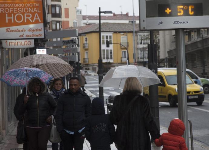 Una persona pasea junto a un termómetro de Vitoria.