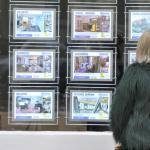 Una mujer mira el escaparate de una inmobiliaria.