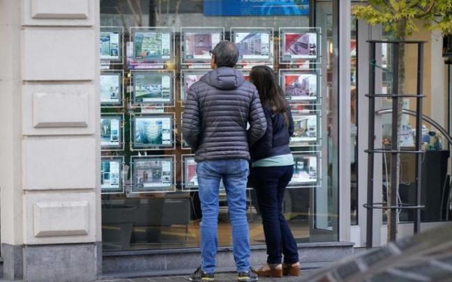 Un pareja mira la oferta de venta de pisos, una de las transacciones donde se cobra el impuesto de plusvalía