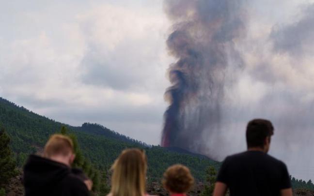Varias personas observan la actividad de la erupción volcánica.