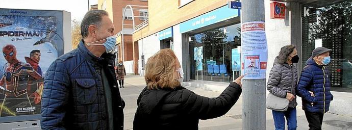 Dos personas fijándose ayer en uno de los carteles que anuncian la desaparición de Bengoa. Foto: Pilar Barco