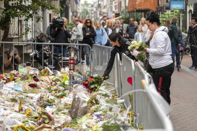 Un grupo de personas dejan flores en recuerdo del periodista asesinado.
