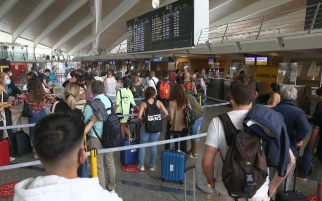 Largas colas ayer jueves ante los mostradores de facturación con el panel de salidas casi lleno.