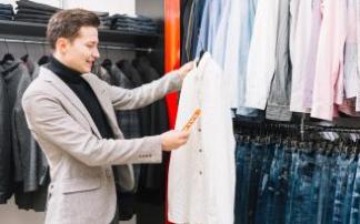 Un hombre elige una camisa de un perchero.