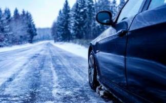 Un coche circulando por una carretera con nieve.