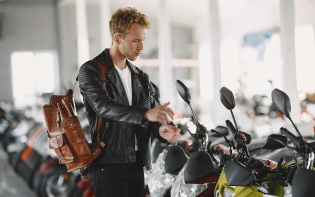 Un joven revisa una moto en un concesionario.