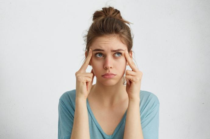 Una joven con ojeras, en actitud pensativa.