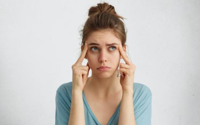 Una joven con ojeras, en actitud pensativa.