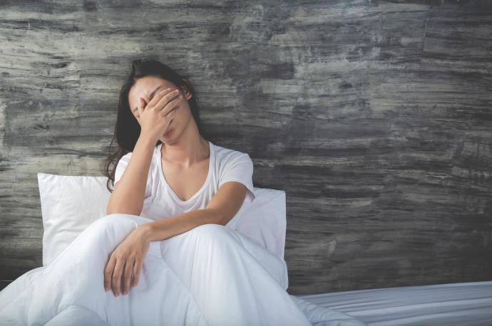 Una mujer angustiada sentada en la cama.