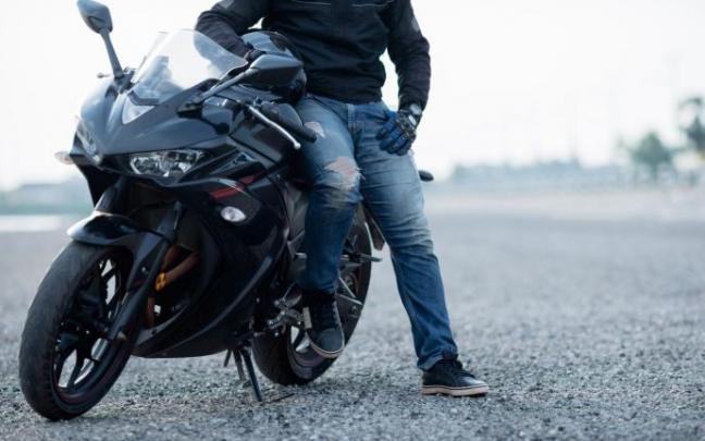 Un hombre junto a su moto. Un hombre junto a su moto.