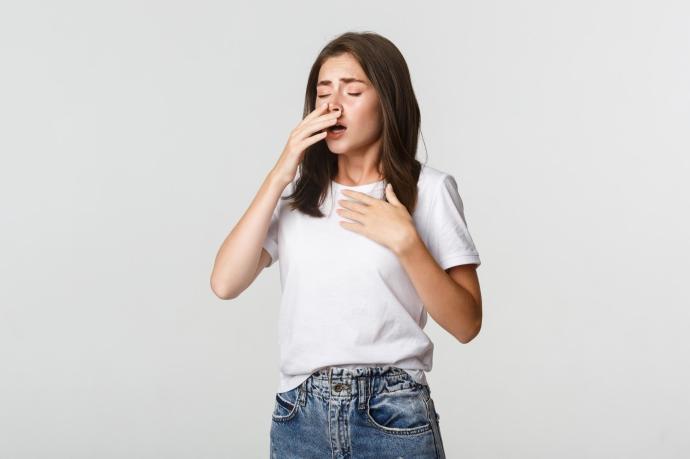 Una joven a punto de estornudar.