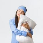 Una mujer con un antifaz y una almohada antes de ir a dormir.